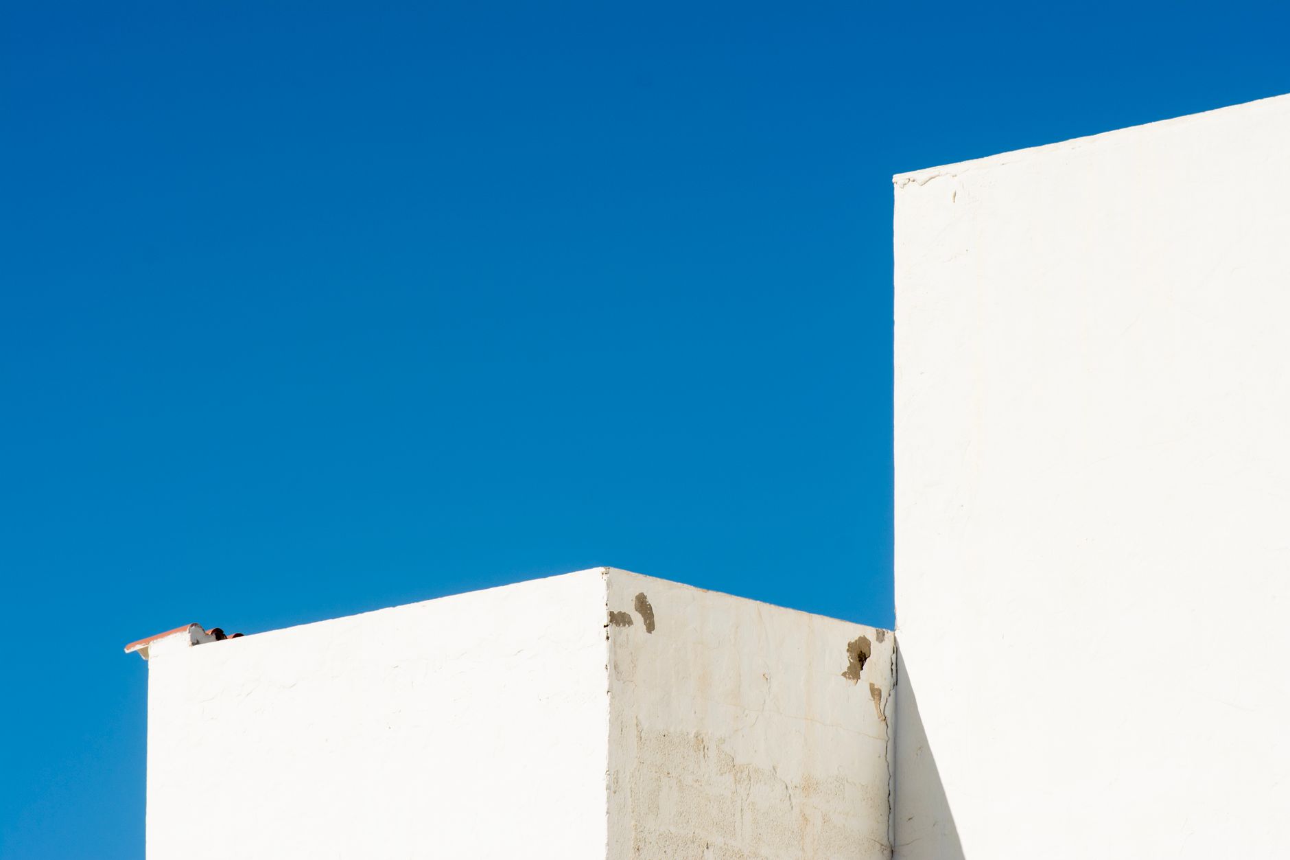 White rendered houses against a clear sky.